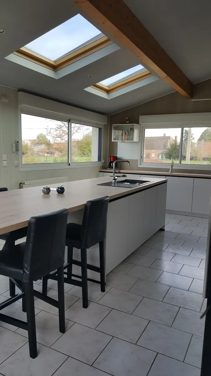 Grande cuisine contemporaine avec îlot et puits de lumière velux