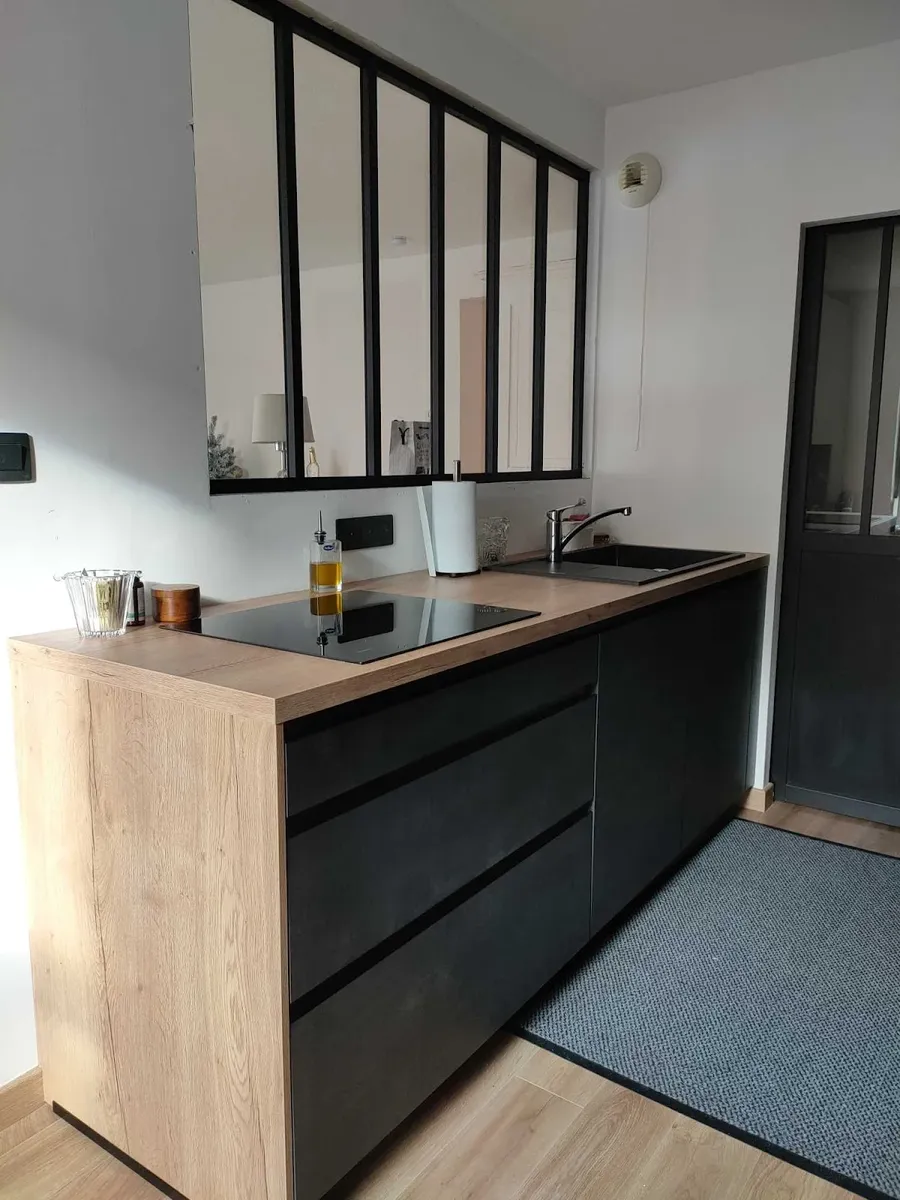Linéaire de cuisine avec plan de travail bois devant verrière atelier d'artiste